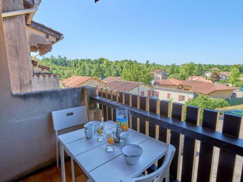 a white table on a balcony with a view at Studio lumineux proche Lac de l'Uby avec Wi-Fi gratuit - FR-1-841-55 in Barbotan-les-Thermes