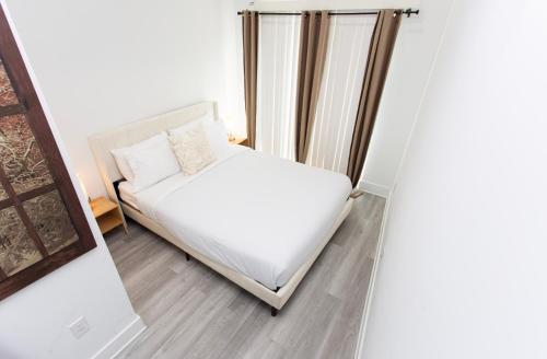 a bedroom with a bed with white sheets at Lux Capitol Hill Vacation Home, In-House Services in Washington