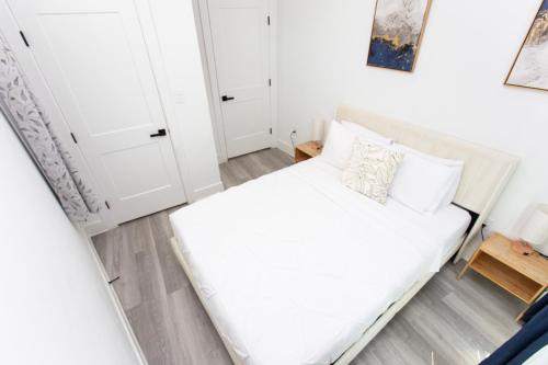 a small bedroom with a white bed and white cabinets at Lux Capitol Hill Vacation Home, In-House Services in Washington