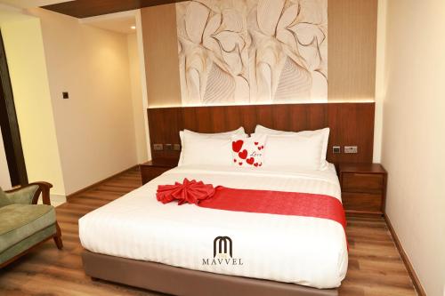 a bedroom with a bed with a red bow on it at The Mavvel Hotel in Kangaru