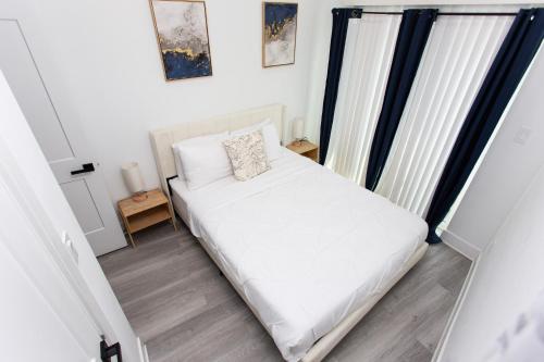 a bedroom with a white bed and a window at Lux Capitol Hill Vacation Home, In-House Services in Washington
