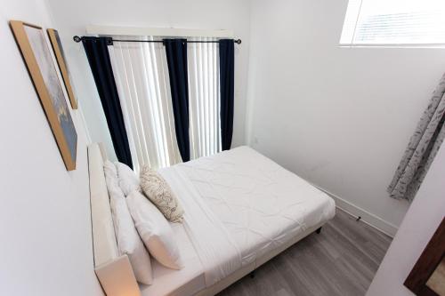 a white bed in a room with a window at Lux Capitol Hill Vacation Home, In-House Services in Washington