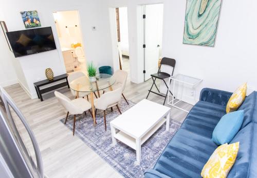 a living room with a blue couch and a table at Lux Capitol Hill Vacation Home, In-House Services in Washington