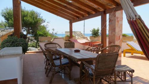 a wooden table and chairs on a patio at Villa Bruno in Maruggio