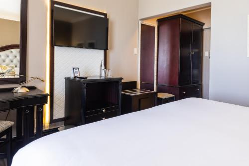 a hotel room with a bed and a mirror at Premier Hotel Cape Town in Cape Town