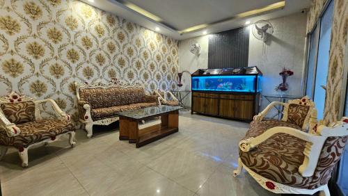 a living room with a couch and a fish tank at Hotel HK Continental in Amritsar