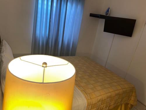 a room with a bed with a table and a television at bamboo bed and breakfast in San Pedro Sula