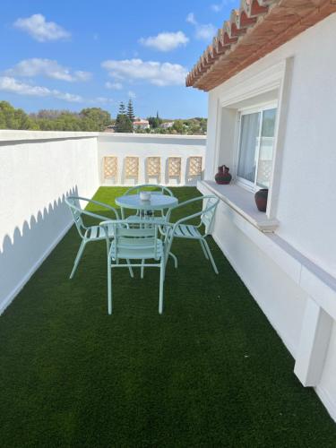 a table and chairs on a balcony with green grass at Aparthotel Bahia Pinosol in Jávea