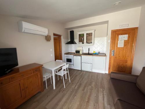 a kitchen with a table and a small kitchen with a table and chairs at Aparthotel Bahia Pinosol in Jávea