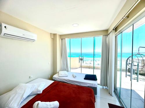 une chambre avec deux lits et une vue sur l'océan dans l'établissement Luxuosa Cobertura Vista Mar- Praia Grande, à Arraial do Cabo
