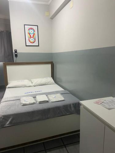 a bedroom with a bed with two towels on it at Hotel Sany SP- Metrô Paulista in Sao Paulo
