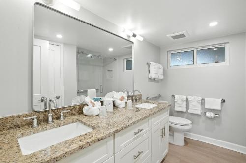 a bathroom with two sinks and a toilet and a large mirror at Lighthouse Resort & Club in Sanibel