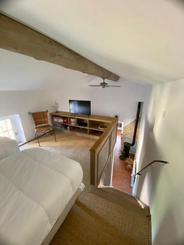 a bedroom with a bed and a desk and a television at La Serre Des Mourgues in Méjannes-lès-Alès