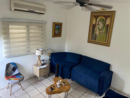 a living room with a blue couch and a table at bamboo bed and breakfast in San Pedro Sula