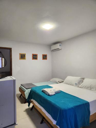 a bedroom with two beds and a flat screen tv at Deck de Búzios in Búzios