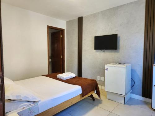 a bedroom with a bed and a tv on the wall at Deck de Búzios in Búzios