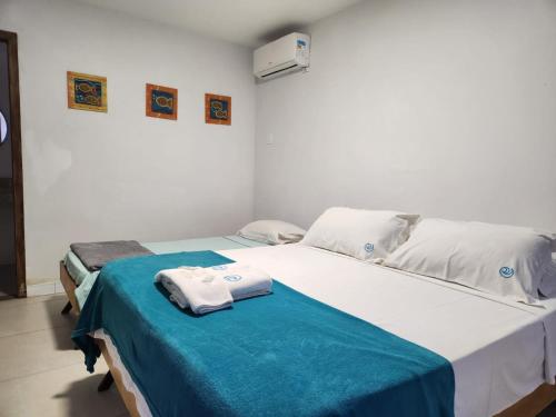 two beds in a room with towels on them at Deck de Búzios in Búzios