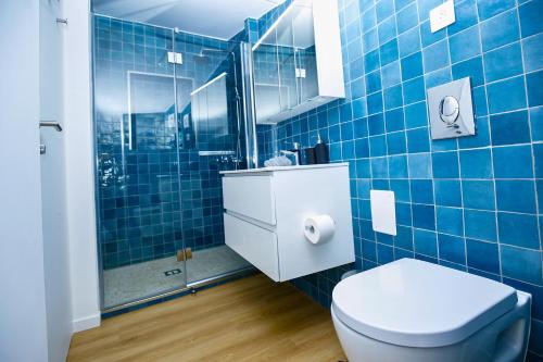 a blue tiled bathroom with a toilet and a shower at Elegante appartmento nel quadrato d'oro a St Tropez in Saint-Tropez