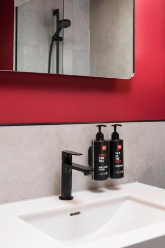 a bathroom sink with two soap bottles on it at Radisson RED London Twickenham in Twickenham