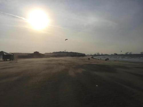 a person is flying a kite on the beach at House in Zingem near Hiking Trails in Zingem
