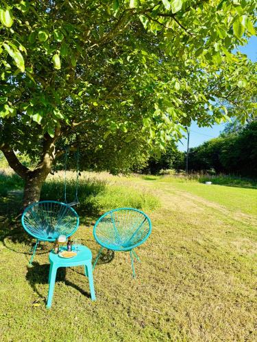 two chairs and a swing in front of a tree at Chadenn in Lannion