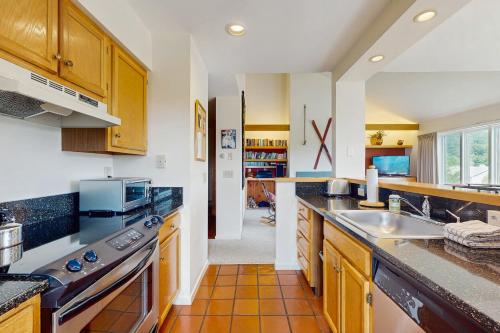 a large kitchen with wooden cabinets and a sink at Snow Creek 115 in Warren