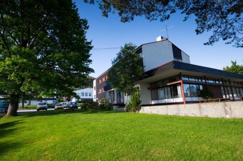 a building with a green lawn in front of it at Molde Vandrerhjem Hostel in Molde