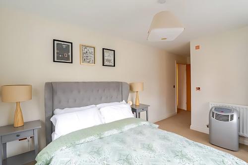NorwoodにあるBeautiful and Modern 2 Bed Flat in Greater Londonのベッドルーム1室(ベッド1台、テーブル2台、ランプ2つ付)