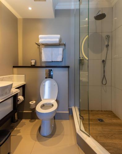 a bathroom with a toilet and a glass shower at Premier Hotel Cape Town in Cape Town