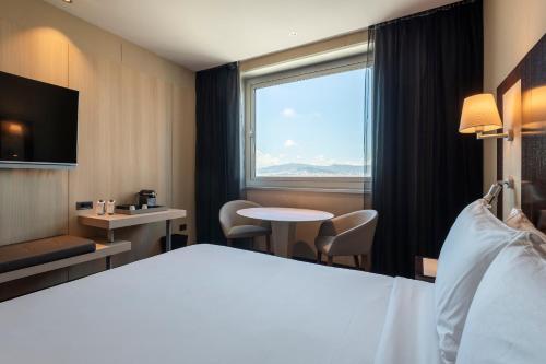 a hotel room with a bed and a large window at Leonardo Royal Hotel Barcelona Forum in Barcelona