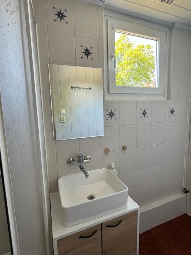 a bathroom with a sink and a mirror and a tub at Beach House Mrzeżyno in Mrzeżyno