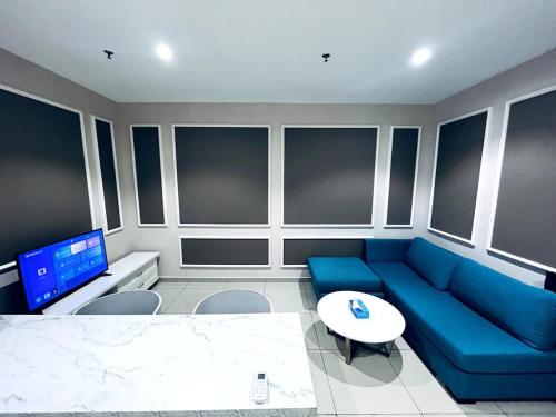 a living room with a blue couch and a table at Gem Homes at i-City - WiFi TV Box and 1 Carpark in Shah Alam