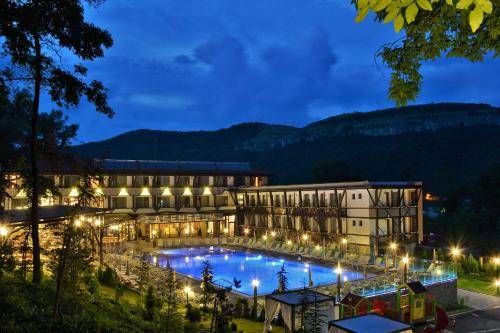 un hotel con piscina por la noche en Park Hotel Asenevtsi en Veliko Tŭrnovo
