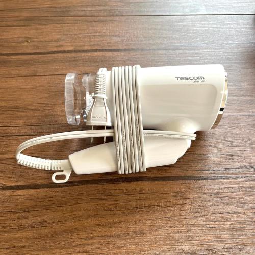 a white electric hair dryer on a wooden table at Guest House Loyal HAKATA in Fukuoka