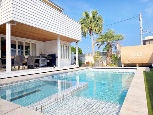 a swimming pool in front of a house at Naminoma Blue 青島 in Miyazaki