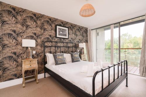 a bedroom with a bed and a wall of wallpaper at Ducklings CW65 Lower Mill Estate Cotswolds in Somerford Keynes