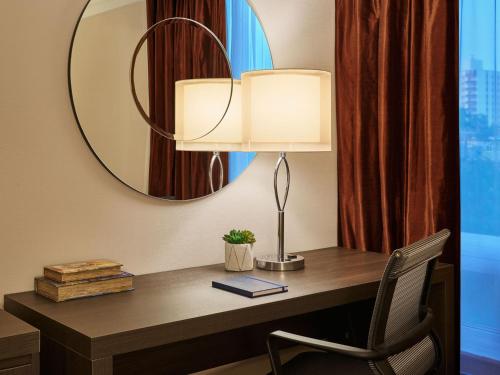 a desk with a lamp and a mirror at Varscona Hotel on Whyte in Edmonton