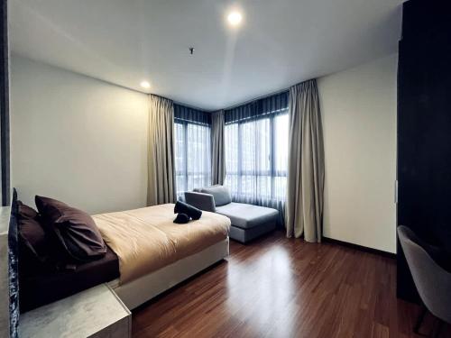 a bedroom with a bed and a chair and a window at Harmony Homes at i-City - free WiFi and 1 Car Park in Shah Alam