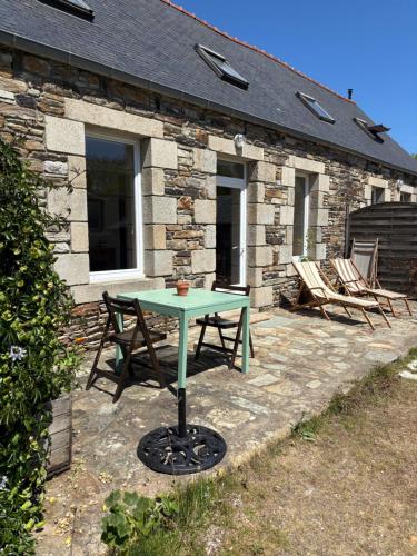a green table and chairs in front of a stone building at Chadenn in Lannion
