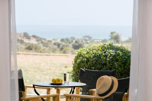 a table and chairs with a hat on top of it at Scala Apartments in Kastraki Naxou