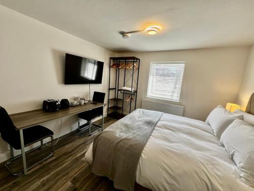 a bedroom with a bed and a desk and a television at Captain's Rest - Kingsize - Kettle - Toaster - Fridge - Sea Front in Saltburn-by-the-Sea