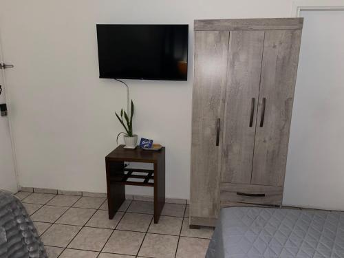 a bedroom with a wooden cabinet and a table with a tv at bamboo bed and breakfast in San Pedro Sula