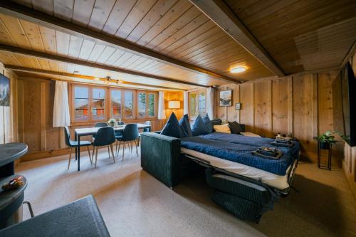 a bedroom with a bed and a table and chairs at Mountain View near Brienz - free parking in Kienholz