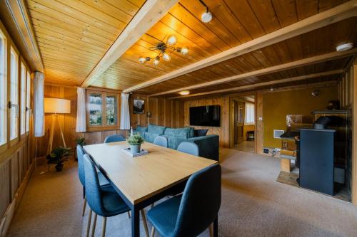 a dining room and living room with a table and chairs at Mountain View near Brienz - free parking in Kienholz