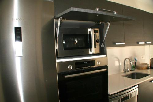 a kitchen with a microwave and a sink at Presciosa Villa Jupiter SOLO FAMILIAS in Cambrils