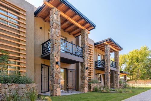an exterior view of a house with stone pillars at Lares De Chacras in Chacras de Coria
