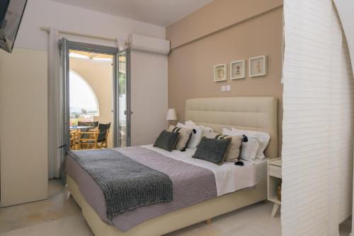 a bedroom with a large bed and a balcony at Scala Apartments in Kastraki Naxou