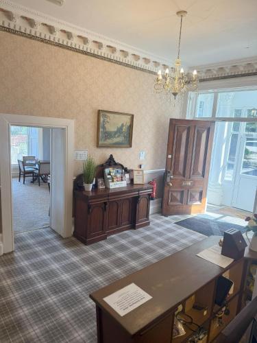 a living room with a desk and a table at Chase Hotel in Whitehaven