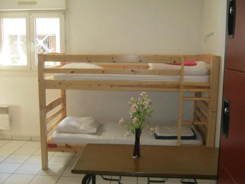 two bunk beds in a room with a table at La Petite Auberge de Saint-Sernin in Toulouse