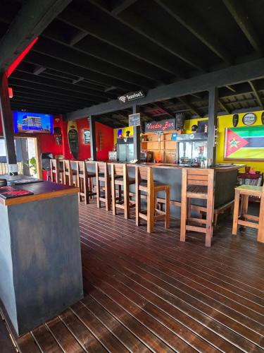 a bar with wooden tables and chairs in a restaurant at Sunrise Beach Lodge in Ponta Malongane